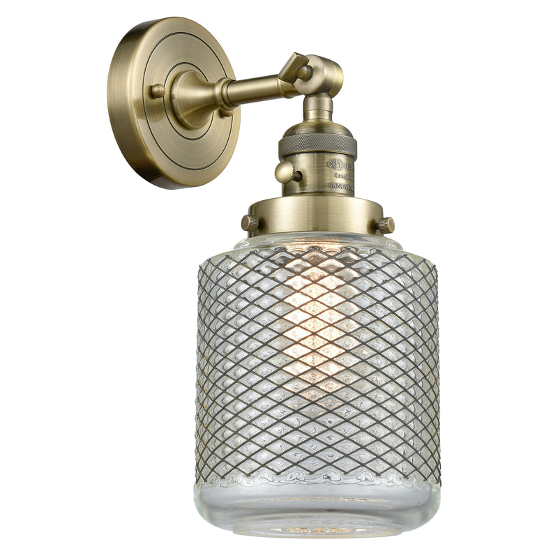 Stanton Sconce shown in the Antique Brass finish with a Clear Wire Mesh shade