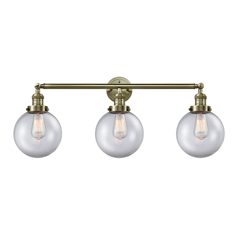 Beacon Bath Vanity Light shown in the Antique Brass finish with a Clear shade