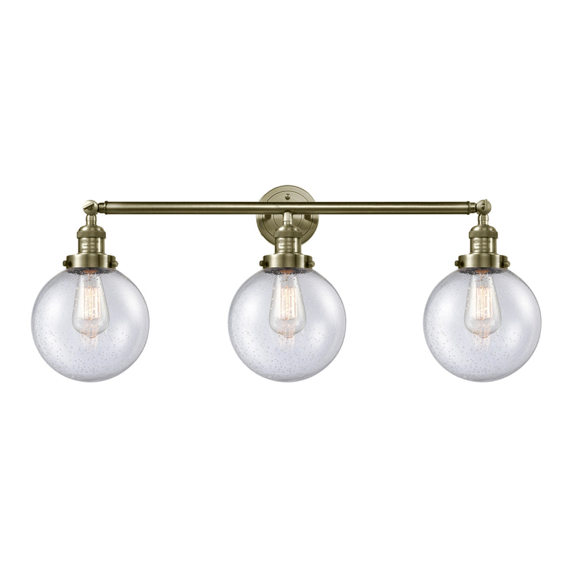 Beacon Bath Vanity Light shown in the Antique Brass finish with a Seedy shade