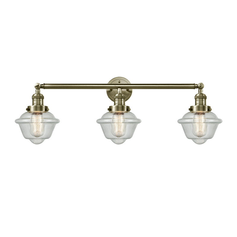 Oxford Bath Vanity Light shown in the Antique Brass finish with a Seedy shade