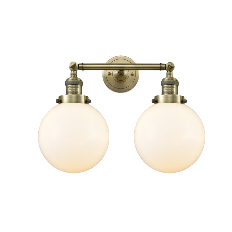 Beacon Bath Vanity Light shown in the Antique Brass finish with a Matte White shade