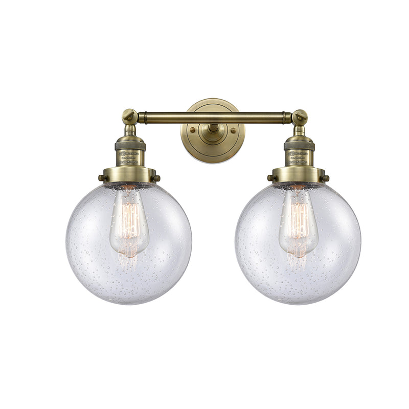 Beacon Bath Vanity Light shown in the Antique Brass finish with a Seedy shade