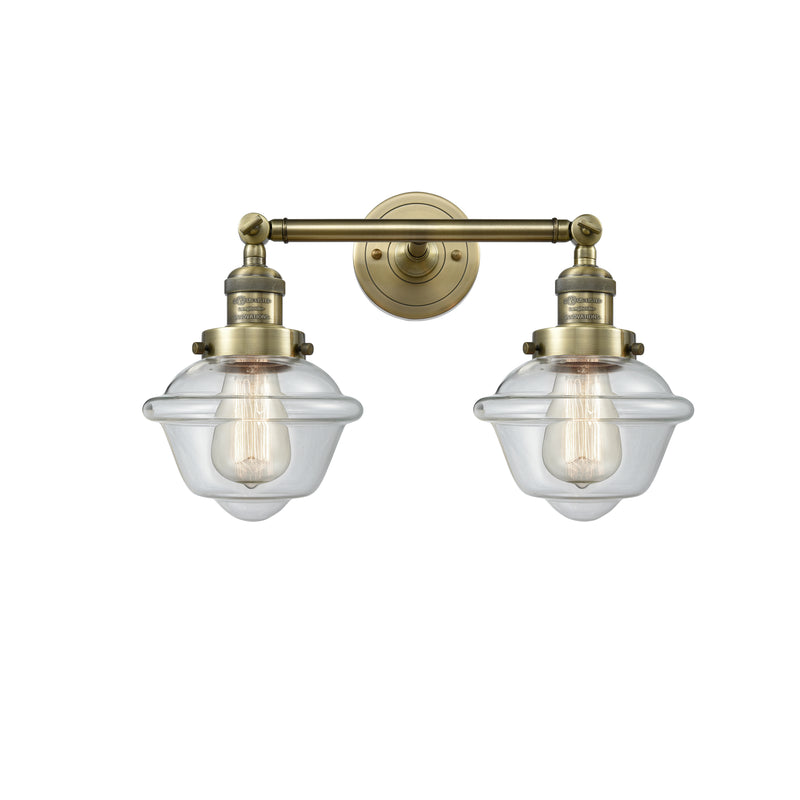 Oxford Bath Vanity Light shown in the Antique Brass finish with a Clear shade