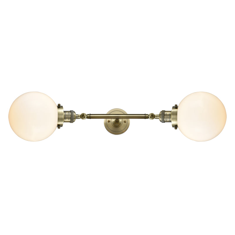 Beacon Bath Vanity Light shown in the Antique Brass finish with a Matte White shade