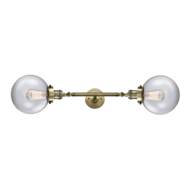 Beacon Bath Vanity Light shown in the Antique Brass finish with a Clear shade