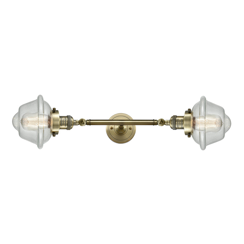 Oxford Bath Vanity Light shown in the Antique Brass finish with a Seedy shade