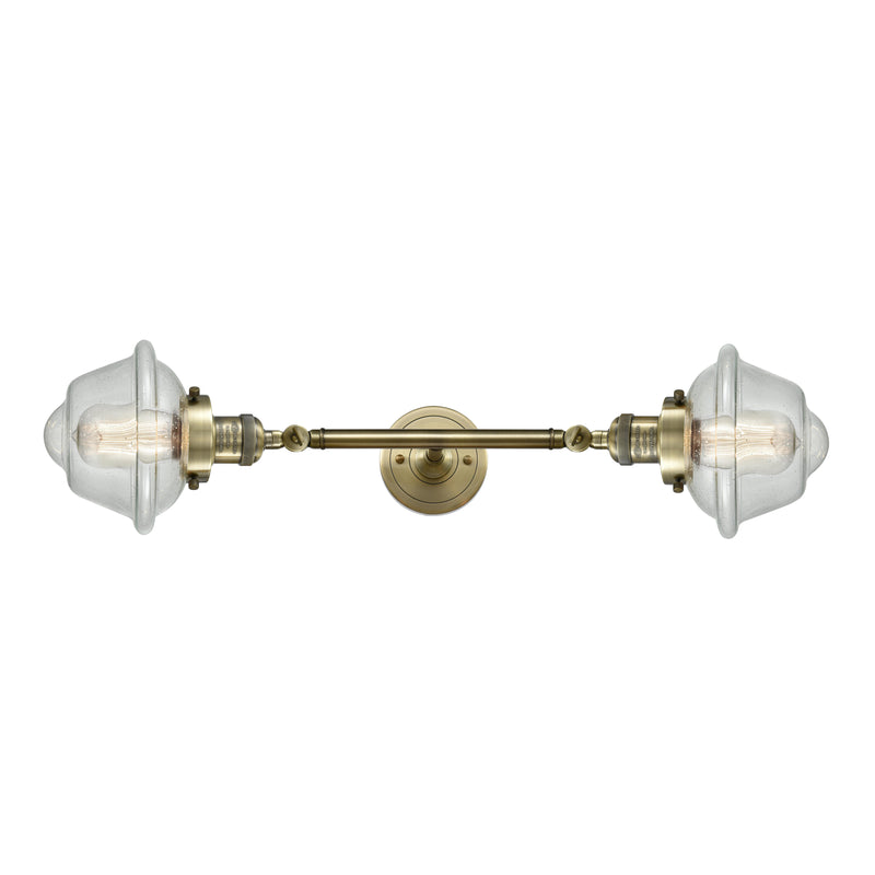 Oxford Bath Vanity Light shown in the Antique Brass finish with a Seedy shade