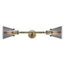 Cone Bath Vanity Light shown in the Antique Brass finish with a Plated Smoke shade