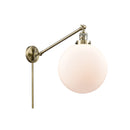 Beacon Swing Arm shown in the Antique Brass finish with a Matte White shade