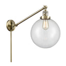 Beacon Swing Arm shown in the Antique Brass finish with a Clear shade