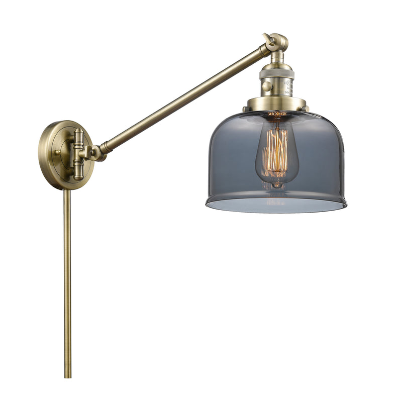 Bell Swing Arm shown in the Antique Brass finish with a Plated Smoke shade