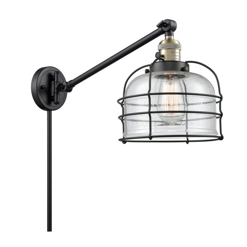 Bell Cage Swing Arm shown in the Black Antique Brass finish with a Seedy shade