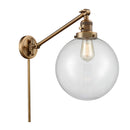 Beacon Swing Arm shown in the Brushed Brass finish with a Clear shade