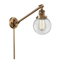 Beacon Swing Arm shown in the Brushed Brass finish with a Clear shade