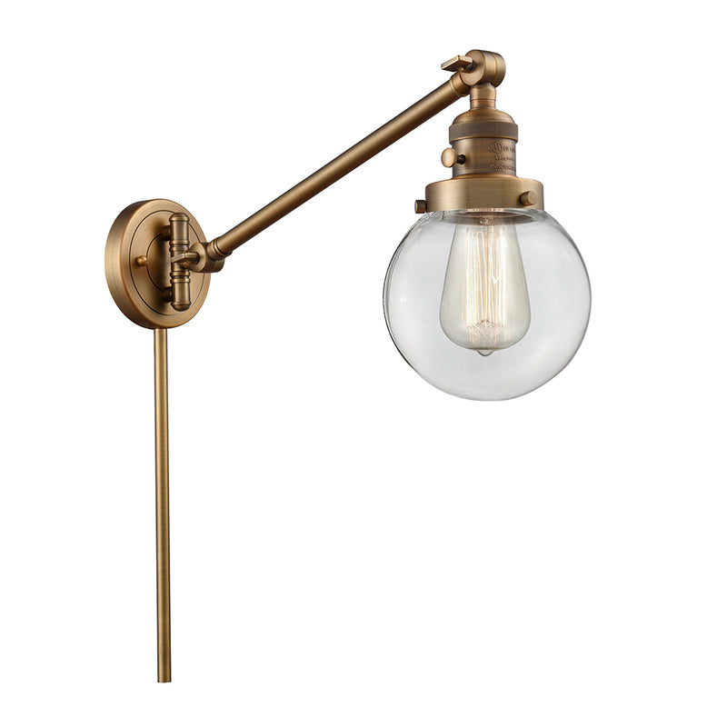 Beacon Swing Arm shown in the Brushed Brass finish with a Clear shade