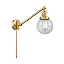 Beacon Swing Arm shown in the Satin Gold finish with a Seedy shade