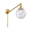 Beacon Swing Arm shown in the Satin Gold finish with a Seedy shade