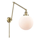 Beacon Swing Arm shown in the Antique Brass finish with a Matte White shade