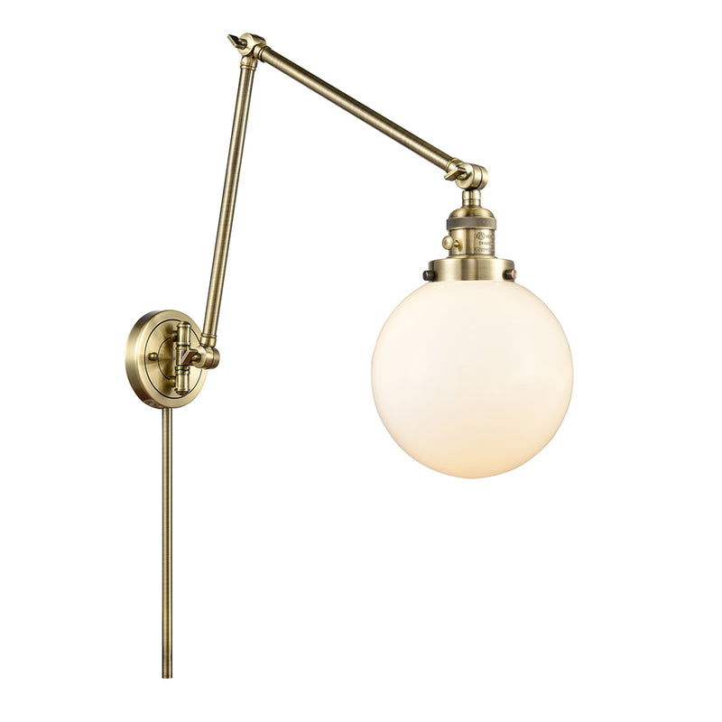 Beacon Swing Arm shown in the Antique Brass finish with a Matte White shade