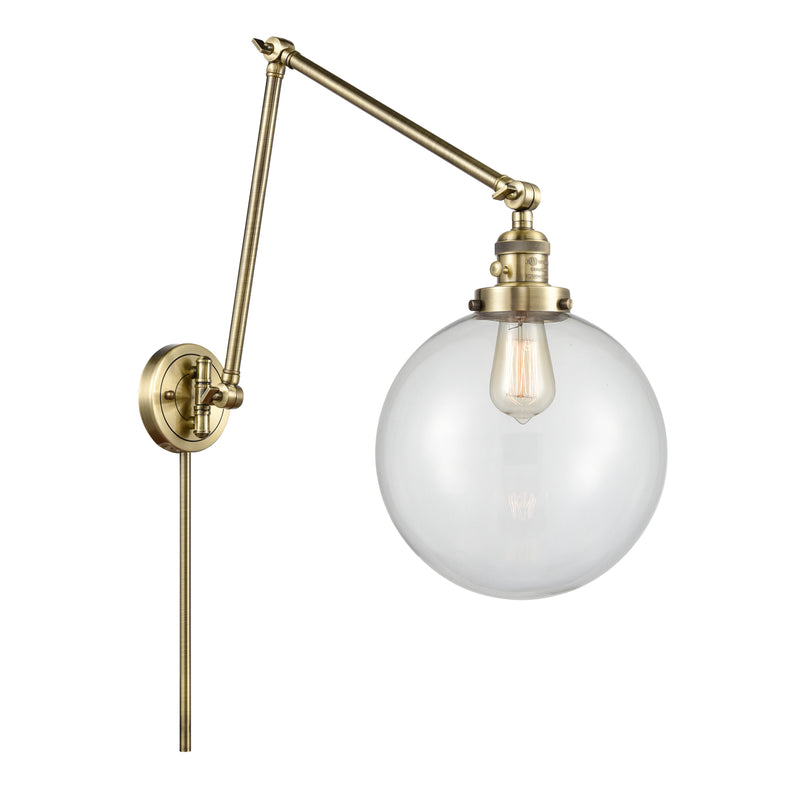 Beacon Swing Arm shown in the Antique Brass finish with a Clear shade