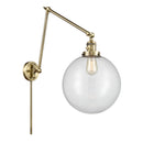 Beacon Swing Arm shown in the Antique Brass finish with a Clear shade