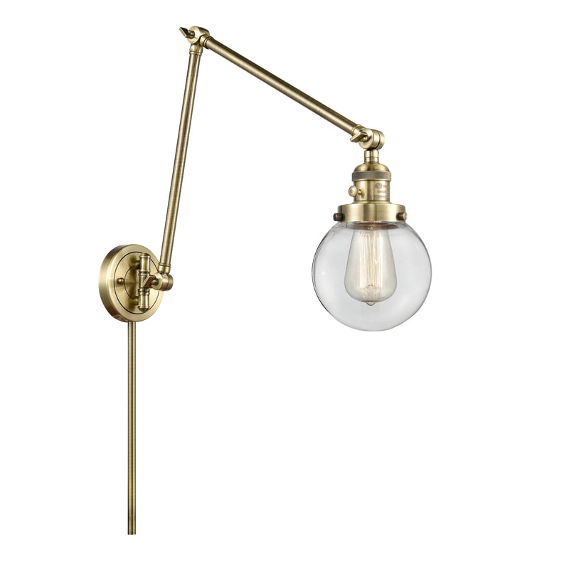 Beacon Swing Arm shown in the Antique Brass finish with a Clear shade