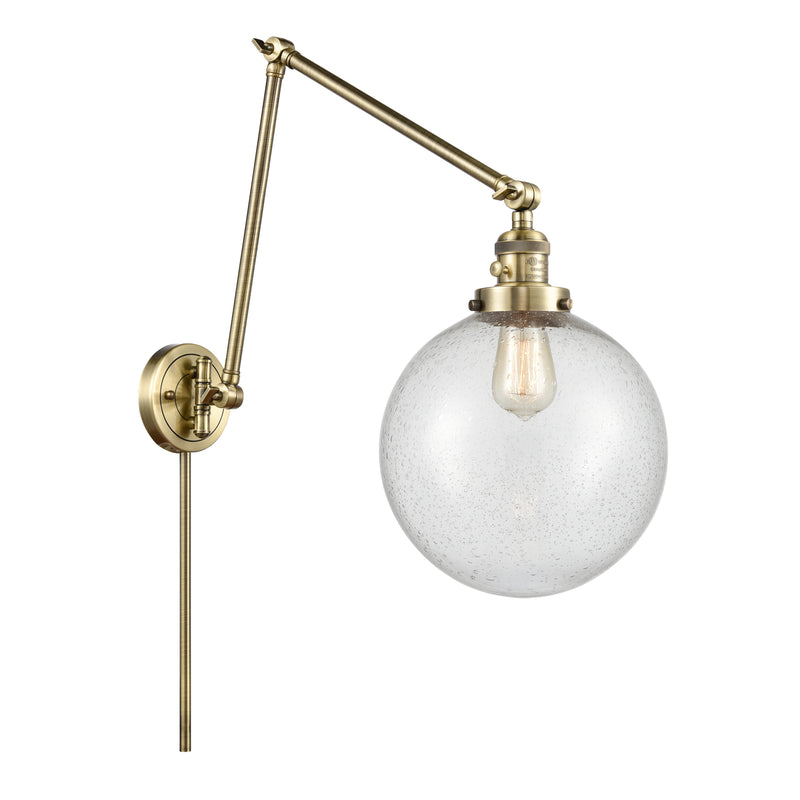 Beacon Swing Arm shown in the Antique Brass finish with a Seedy shade