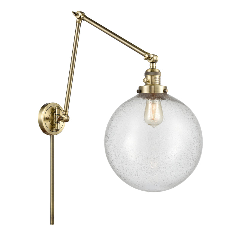 Beacon Swing Arm shown in the Antique Brass finish with a Seedy shade