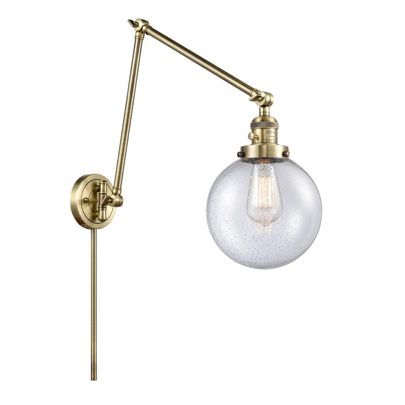 Beacon Swing Arm shown in the Antique Brass finish with a Seedy shade