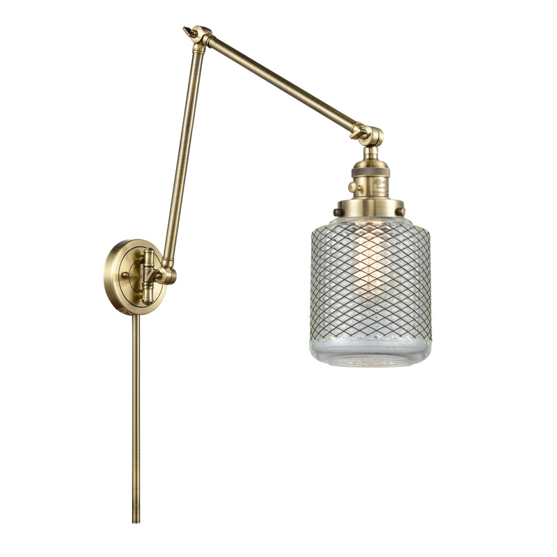 Stanton Swing Arm shown in the Antique Brass finish with a Clear Wire Mesh shade