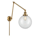 Beacon Swing Arm shown in the Brushed Brass finish with a Clear shade