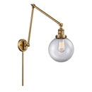 Beacon Swing Arm shown in the Brushed Brass finish with a Clear shade