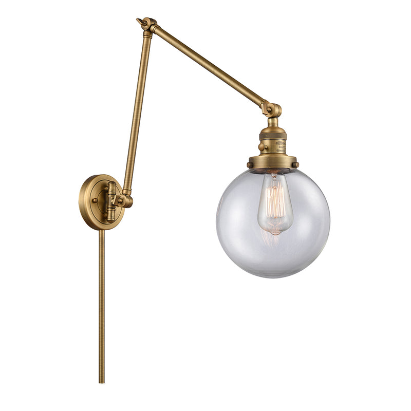 Beacon Swing Arm shown in the Brushed Brass finish with a Clear shade