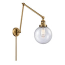 Beacon Swing Arm shown in the Brushed Brass finish with a Seedy shade