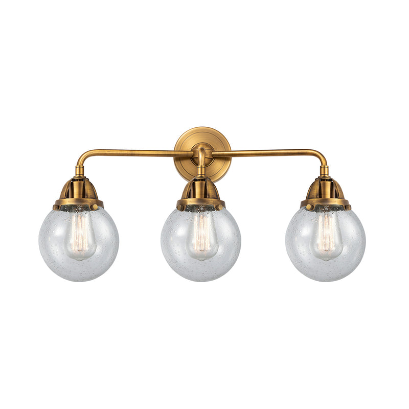 Beacon Bath Vanity Light shown in the Brushed Brass finish with a Seedy shade