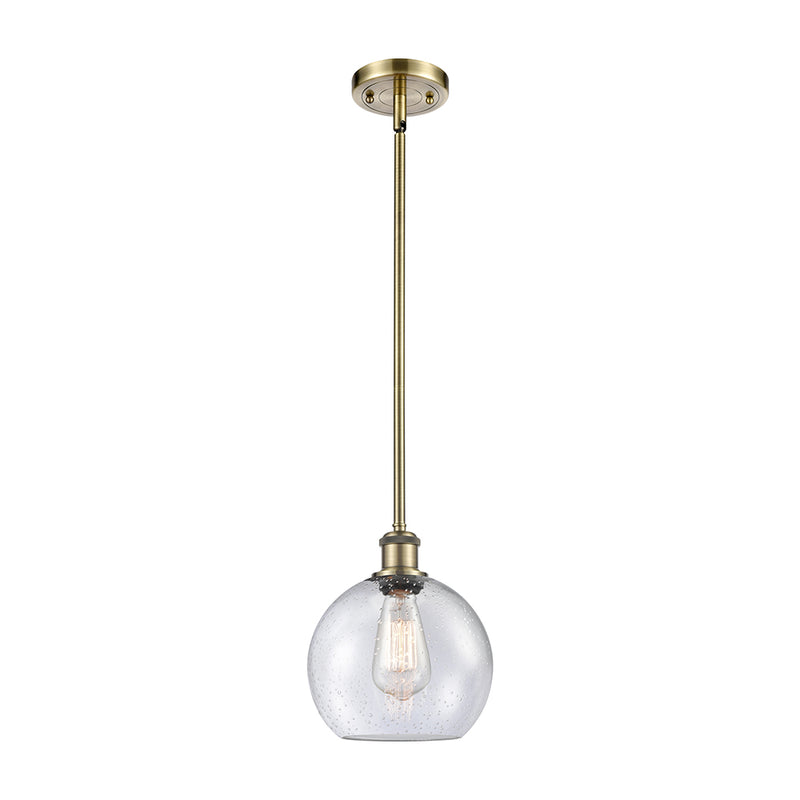 Athens Mini Pendant shown in the Antique Brass finish with a Seedy shade