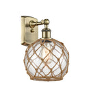 Farmhouse Rope Sconce shown in the Antique Brass finish with a Clear Glass with Brown Rope shade