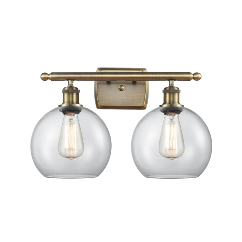 Athens Bath Vanity Light shown in the Antique Brass finish with a Clear shade