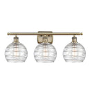 Deco Swirl Bath Vanity Light shown in the Antique Brass finish with a Clear shade