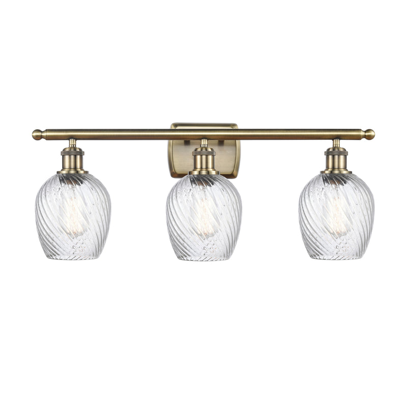 Salina Bath Vanity Light shown in the Antique Brass finish with a Clear Spiral Fluted shade