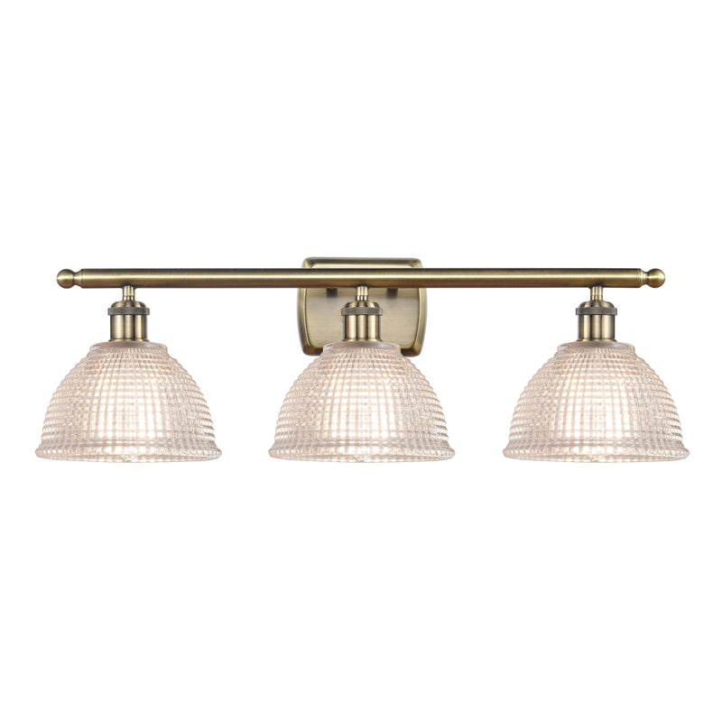 Arietta Bath Vanity Light shown in the Antique Brass finish with a Clear shade