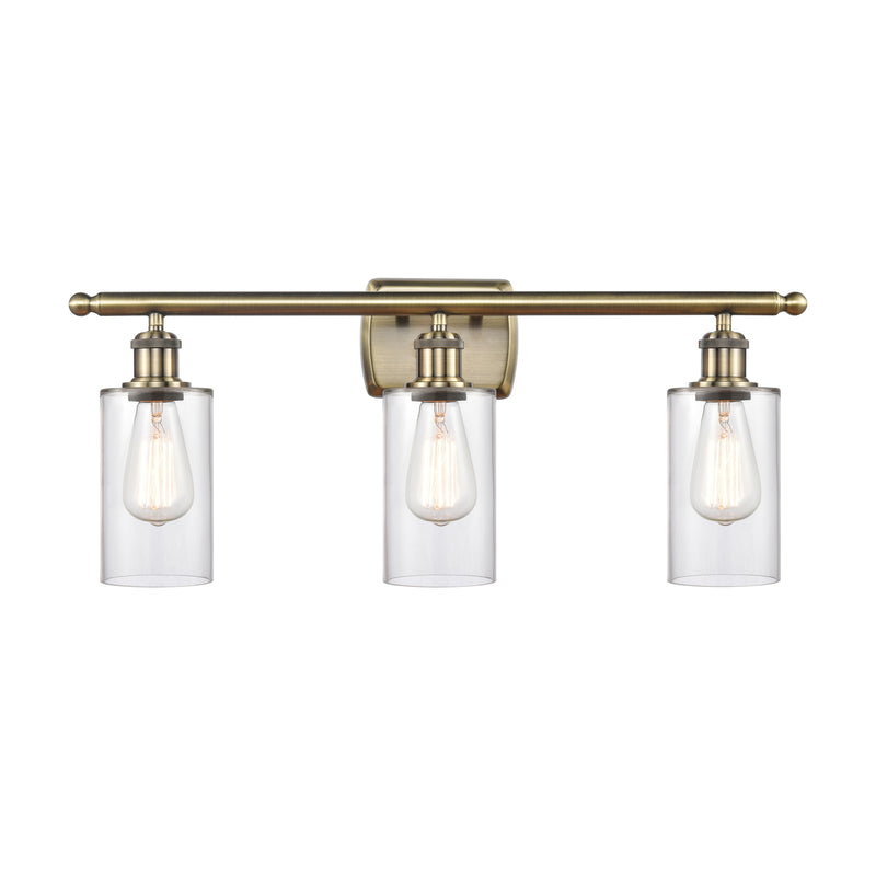 Clymer Bath Vanity Light shown in the Antique Brass finish with a Clear shade