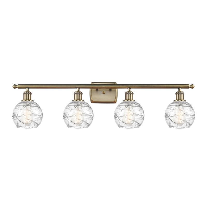 Deco Swirl Bath Vanity Light shown in the Antique Brass finish with a Clear shade