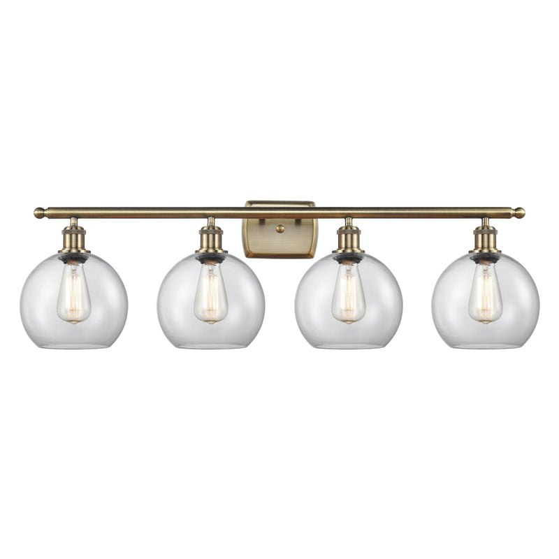 Athens Bath Vanity Light shown in the Antique Brass finish with a Clear shade